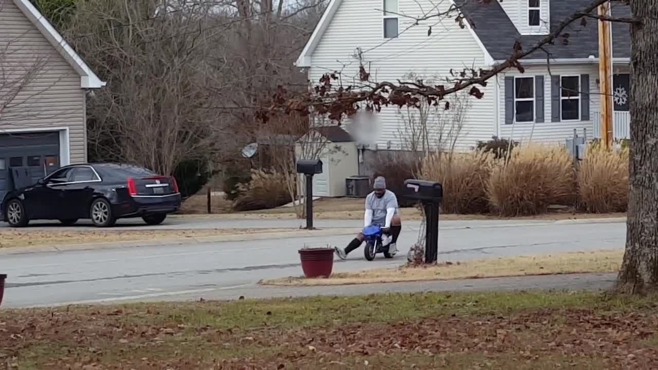 Large Man Driving A Mini Bike
