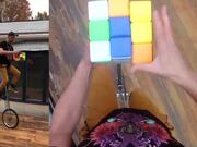 Person Solves Giant Rubik's Cube On Unicycle