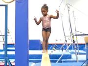 Little Girl Walks On Gymnastic Balance Beam