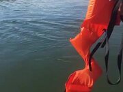 Men in Boat Rescue Monkey with Life Jacket