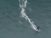 Person Rides Surfboard On High Tides
