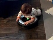 Little Boy Lays on Robot Vacuum Cleaner 