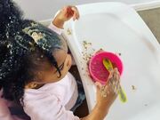 Toddler Applies Baby Food on Her Hair and Face