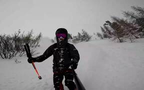 Guy Skis Downhill on Snowy Mountains