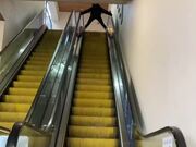 Woman Slides Down Escalator on Roller Skates