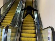 Woman Slides Down Escalator on Roller Skates