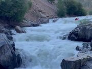 Person Kayaks Downstream in River