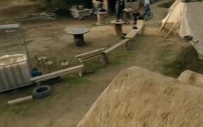 Group of Mountain Bike Riders Jump Over Mud Ramps