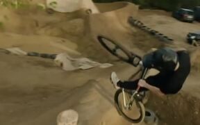 Group of Mountain Bike Riders Jump Over Mud Ramps