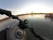Man Rides Motorbike on Frozen Lake