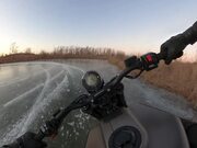 Man Rides Motorbike on Frozen Lake