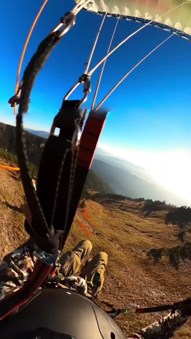 Person Paraglides Smoothly Over Mountain Range