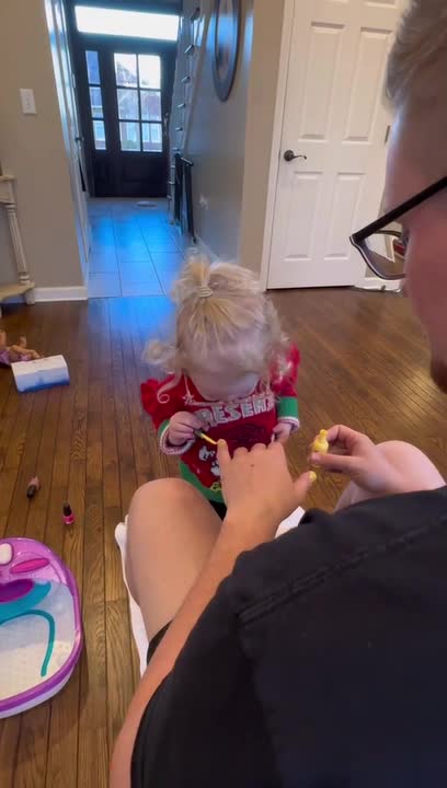Adorable Girl Applies Nail Polish to Her Father