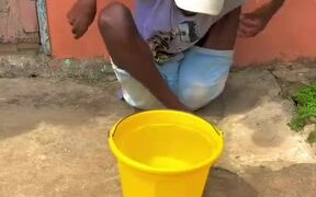 Contortionist Holds a Bucket in Complex Position