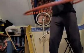Guy Stands on Balance Board and Juggles Balls