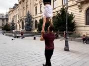 Guy Walks While Balancing Fellow Doing Handstand