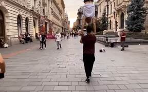 Guy Walks While Balancing Fellow Doing Handstand