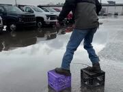 Man Ties Crates to Shoes to Cross Flooded Parking