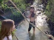 Boy Licks Rock After Picking It Up from Creek
