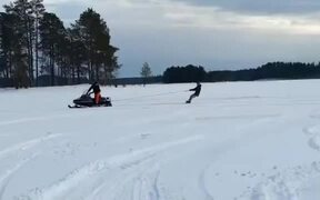 Skier Getting Dragged by Snowmobile