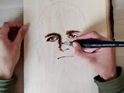 Person Draws Wood Burned Portrait
