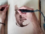 Person Draws Wood Burned Portrait