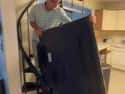 Man Falls Down While Struggling to Carry Large TV