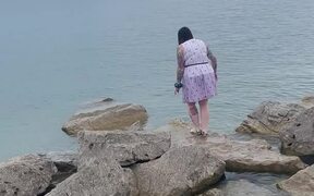 Woman Walking on Rocks Loses Footing and Falls