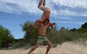 Gymnast Balances on Handstand Over Acrobat