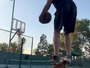 Man Stationed at Bench Shoots Balls Into Basket 