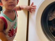 Toddler Curiously Looks at Clothes Spinning