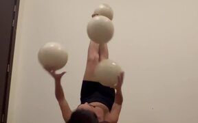 Artist Juggles Balls While Lying on Her Back
