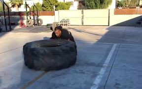 Man Performs Workout Routine by Flipping a Tire
