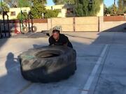 Man Performs Workout Routine by Flipping a Tire