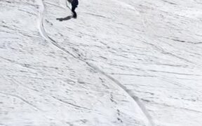 Man Carries His Dog in His Arms While Snowboarding