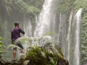 Man Vaping in Front of a Large Waterfall